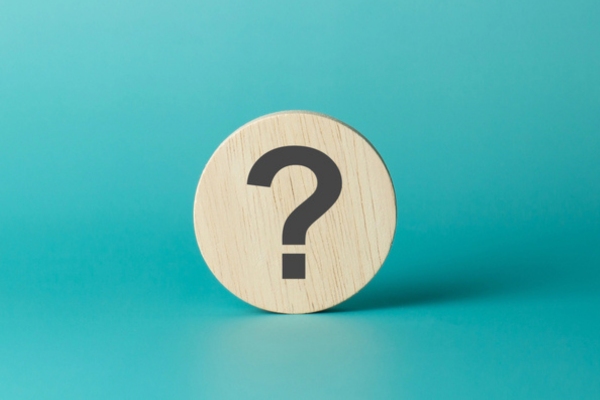 question mark on a wooden circular chip depicting FAQs about propane delivery company