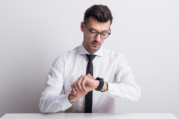 young man looking at his watch depicting How Long Does an Air Conditioner Installation Take