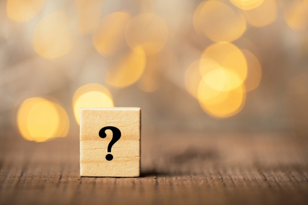 question mark on a wooden chip depicting FAQs about What Size Heating System Do I Need