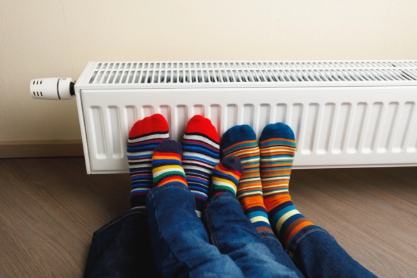 family wearing colorful socks keeping warm by the oil heat radiator