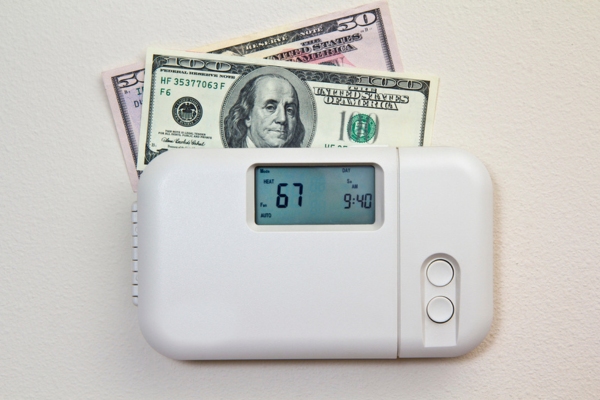 money on top of a digital thermostat