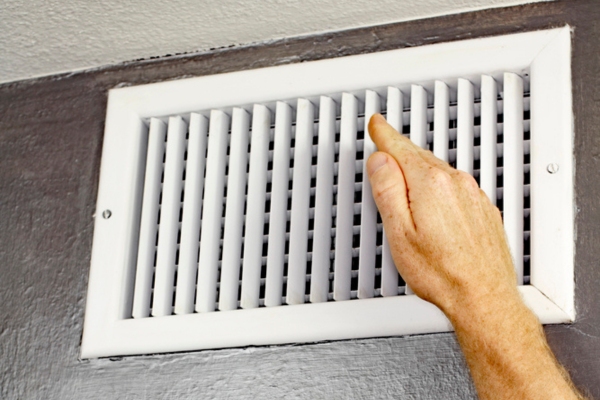 homeowner feeling air coming out of HVAC vent