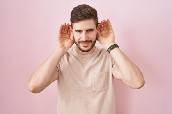 man with beard cupping both his ears listening to unusual HVAC sound
