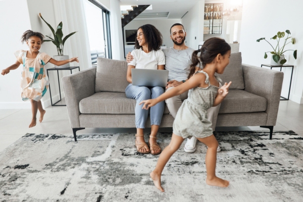 couple lounging on the couch while kids are playing in the living room enjoying cool air conditioning