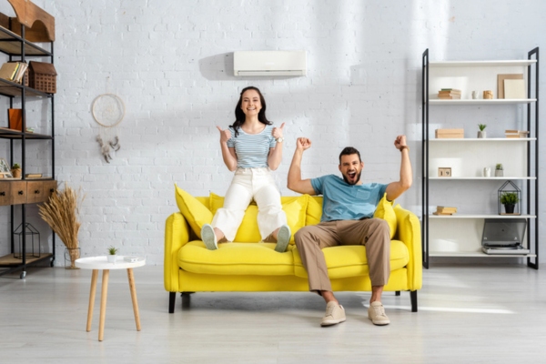 couple sitting on the couch enjoying their new air conditioner system