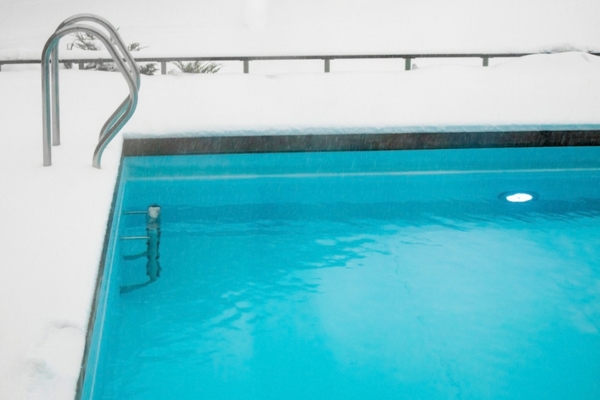 snow surrounding swimming pool